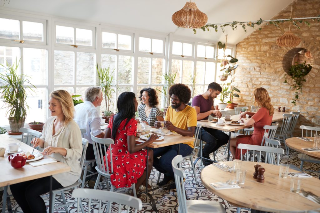 a group of people sitting at tables in a restaurant