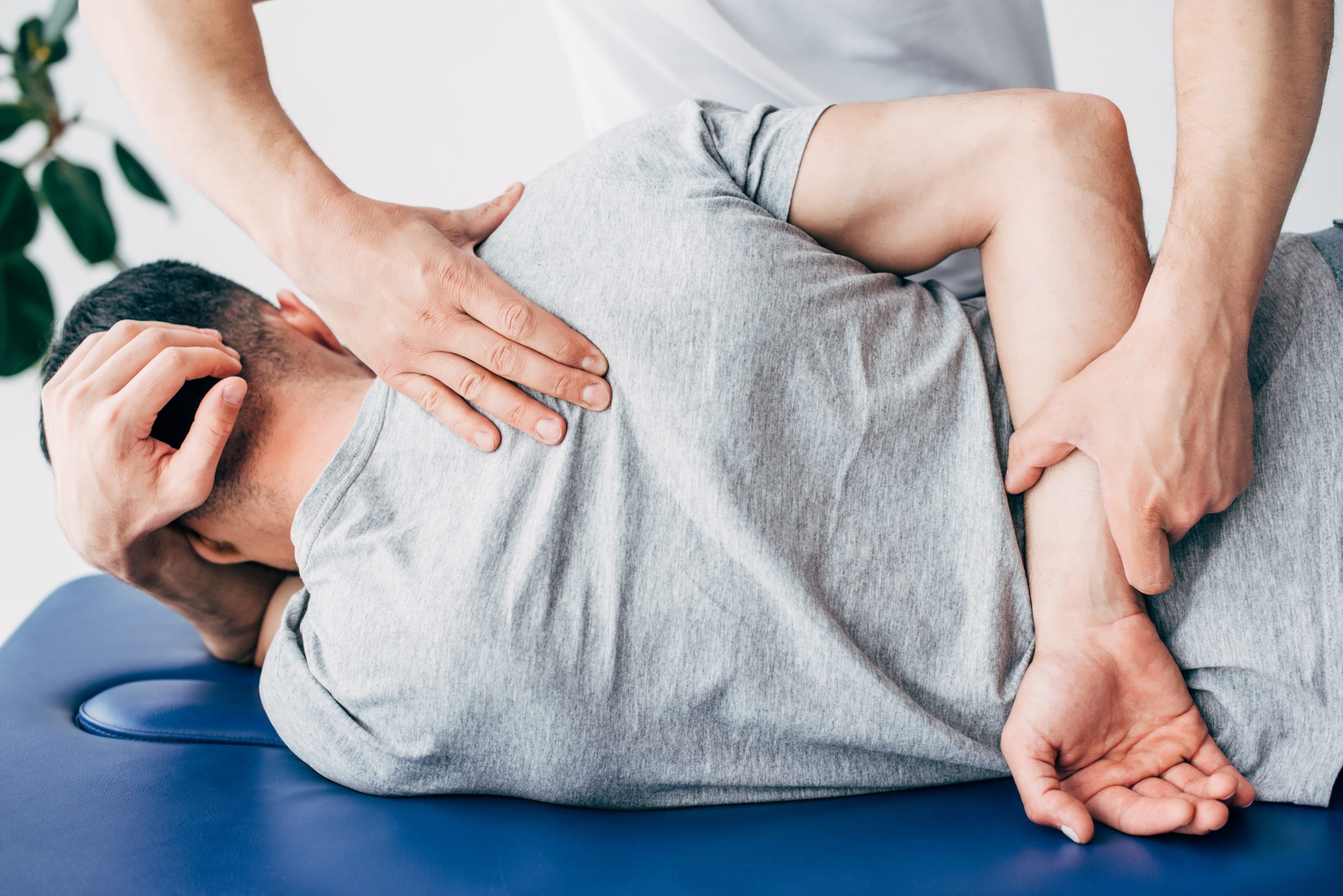 a man lying on a blue surface with hands on his back