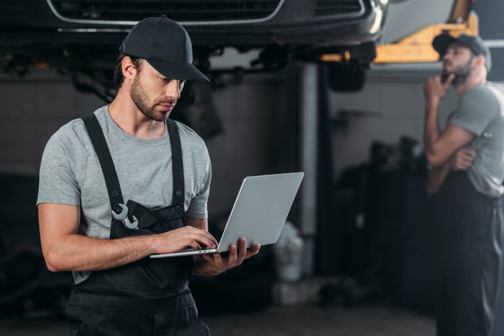 a man in overalls holding a laptop