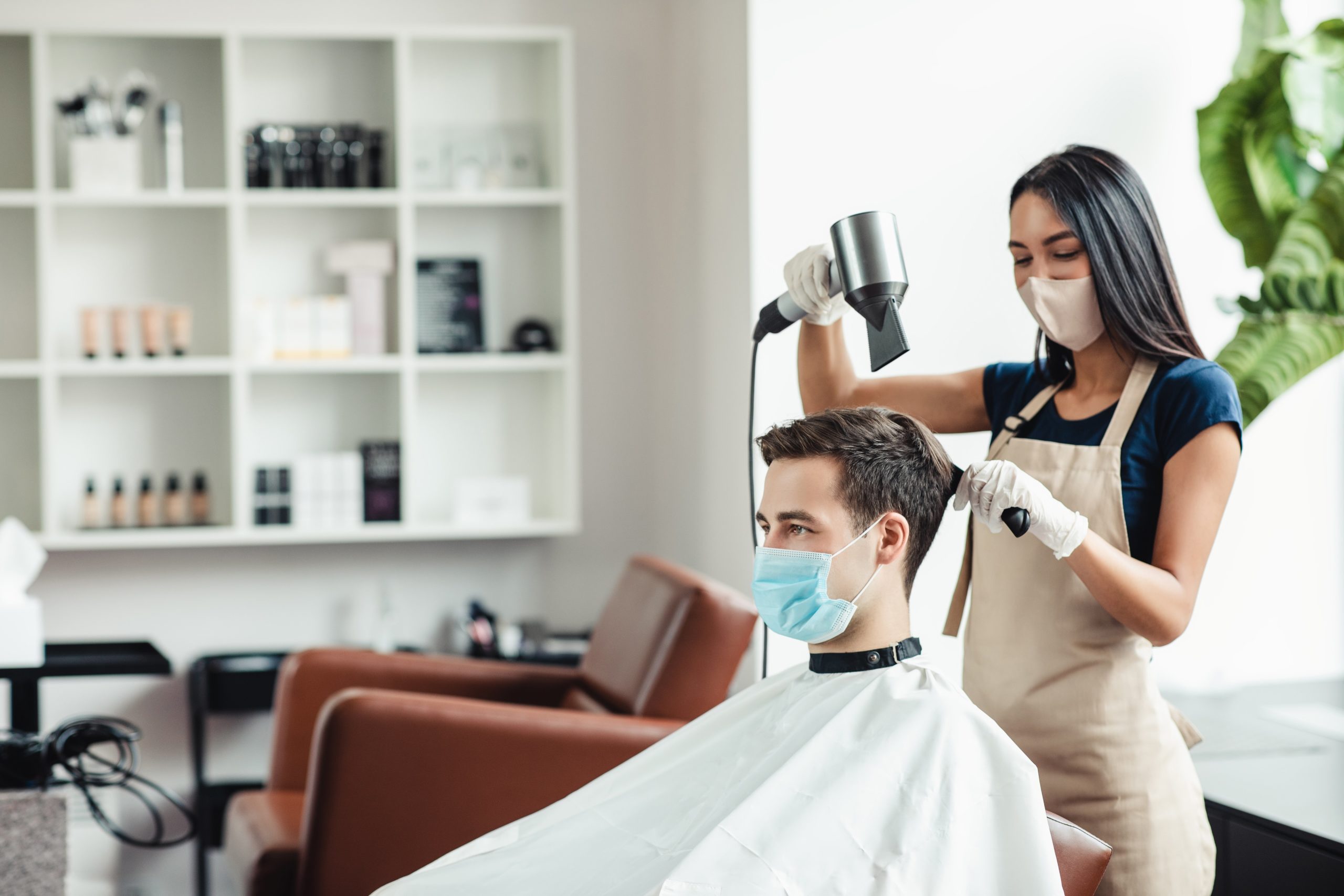 a woman blow drying a man's hair