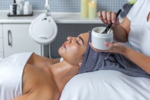 a woman lying down with a jar of cream