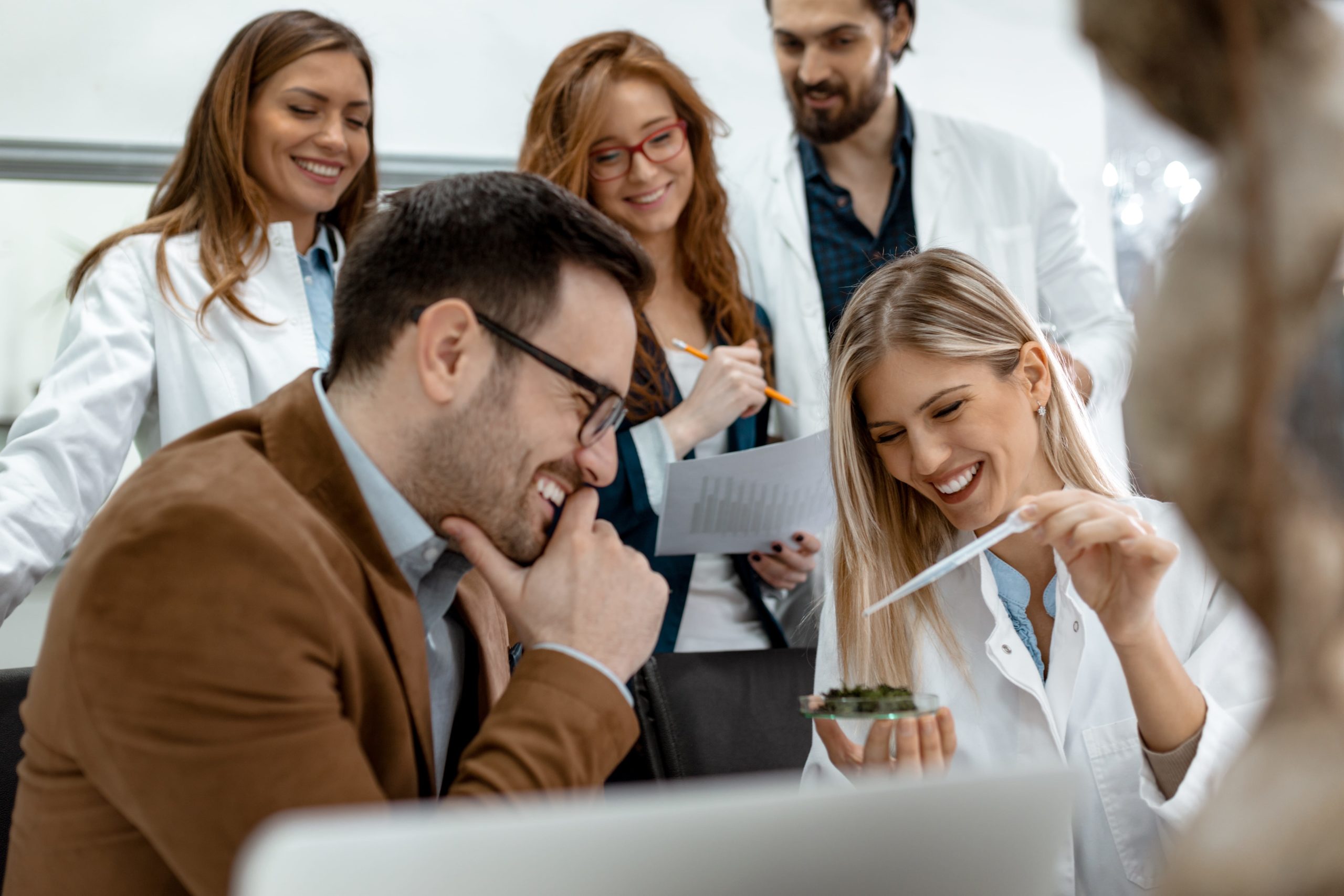 a group of people looking at a test tube