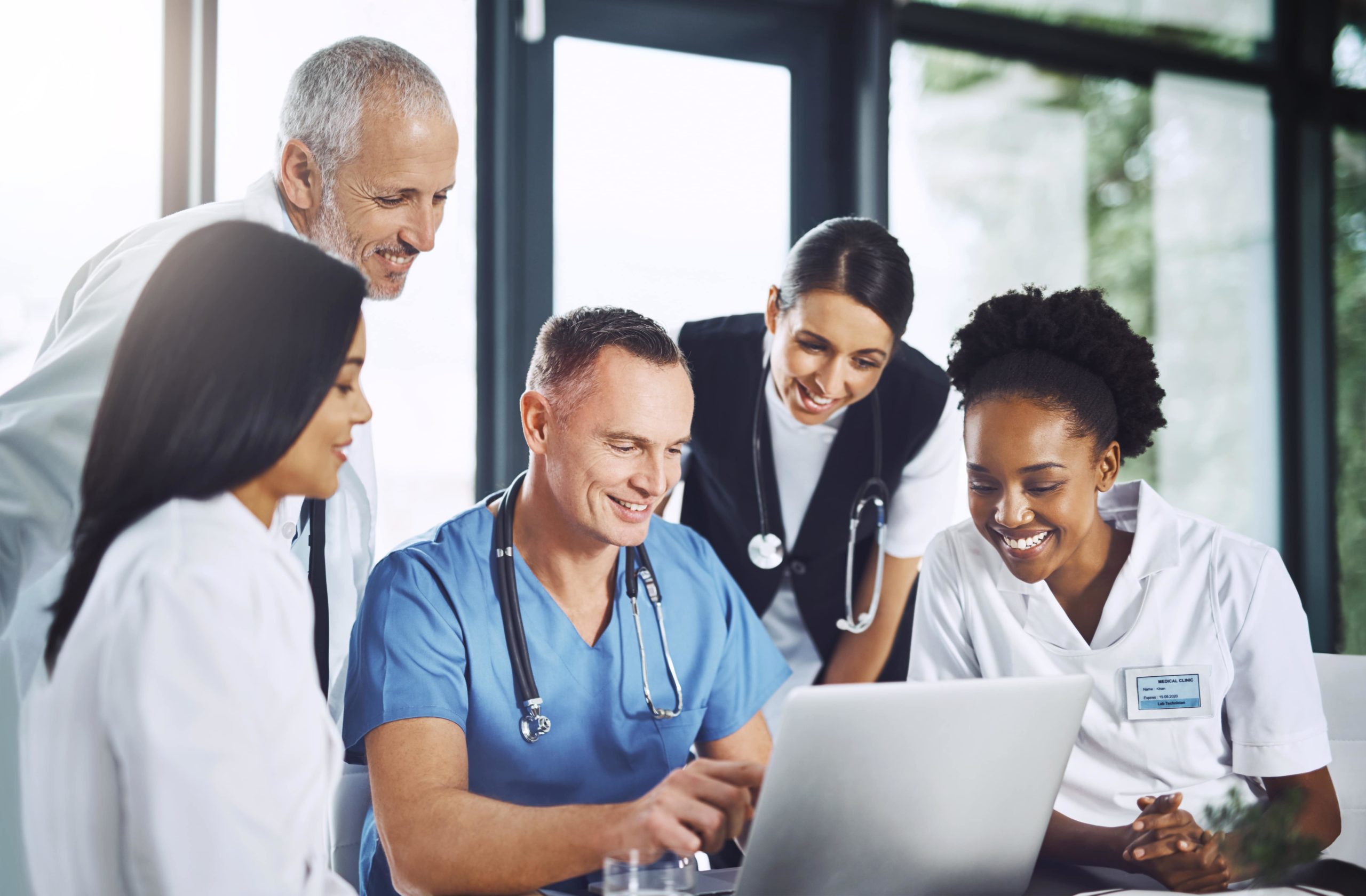 a group of medical doctors looking at a laptop