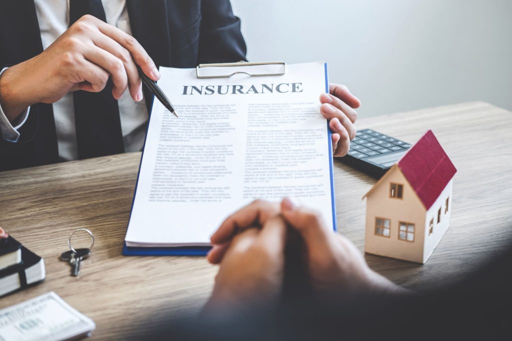 a insurance person holding a pen over a document