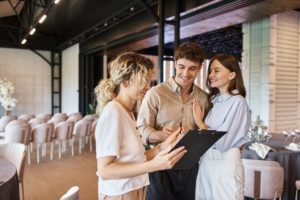 a group of people standing in a room with a wedding planner