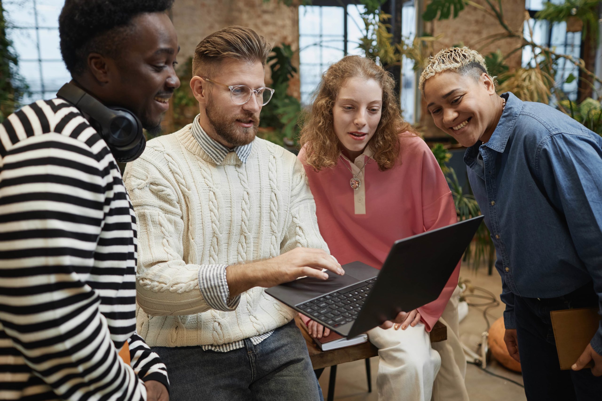 a group of people looking at a laptop