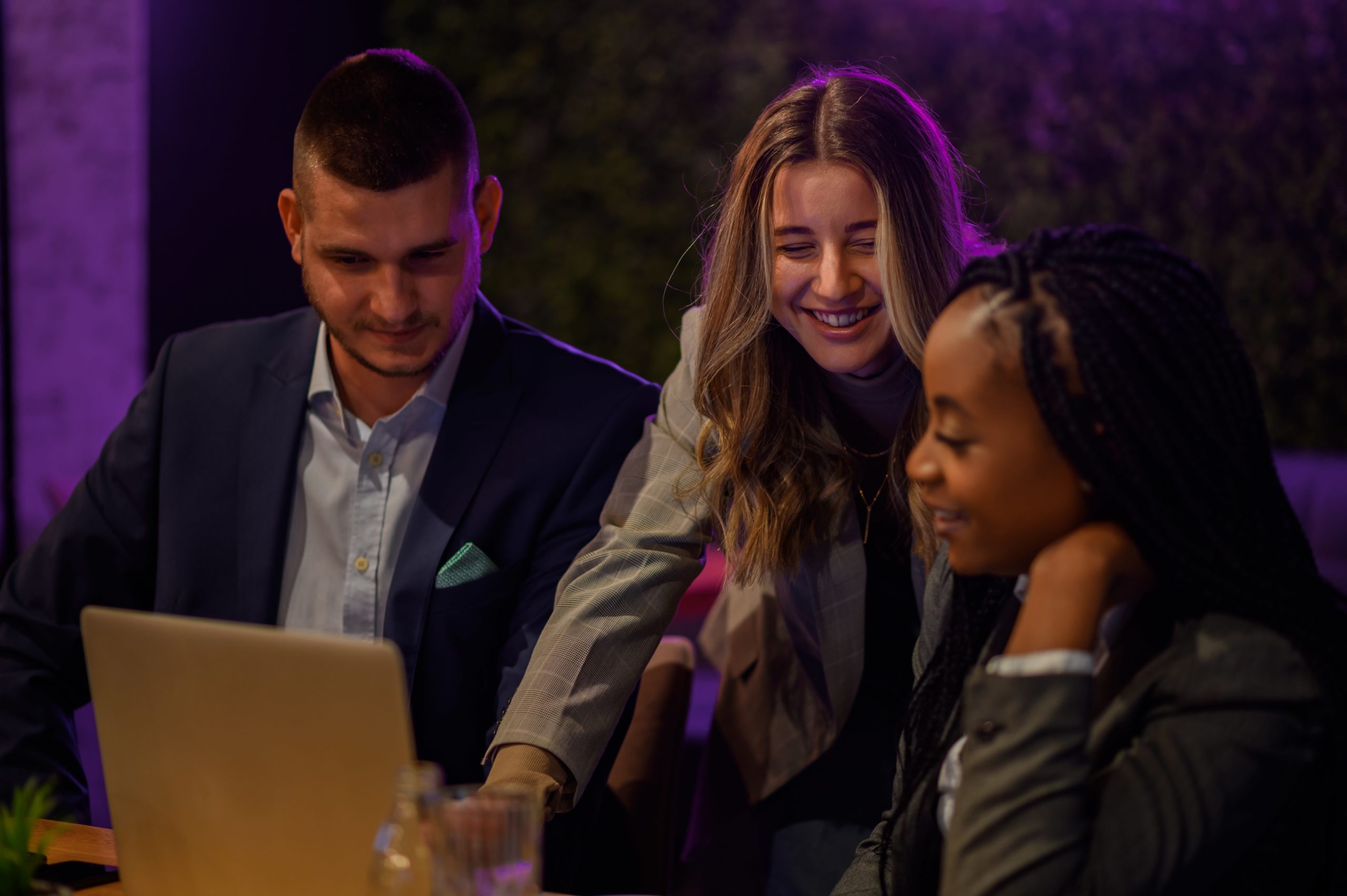 a group of people looking at a laptop