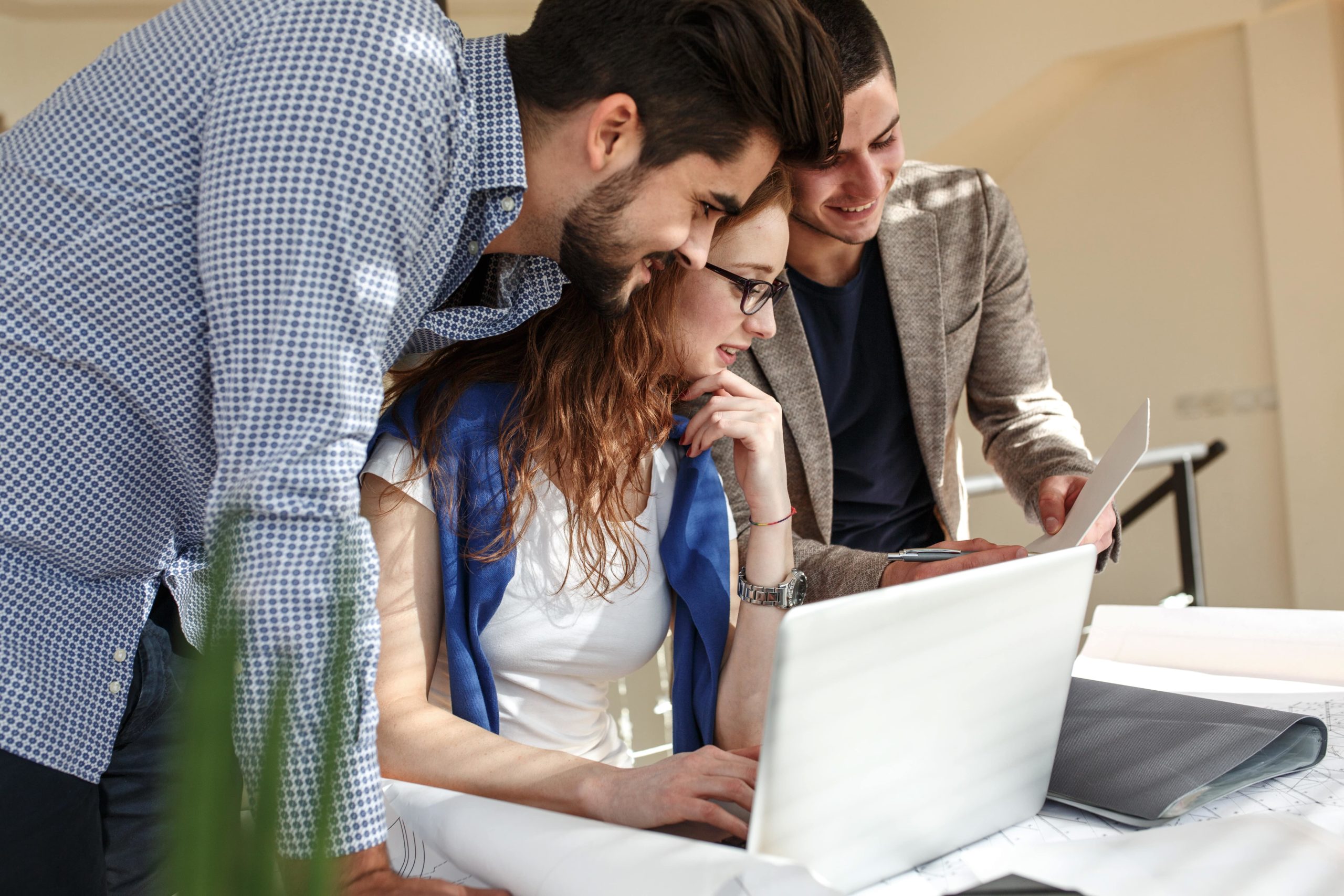 a group of people looking at a laptop