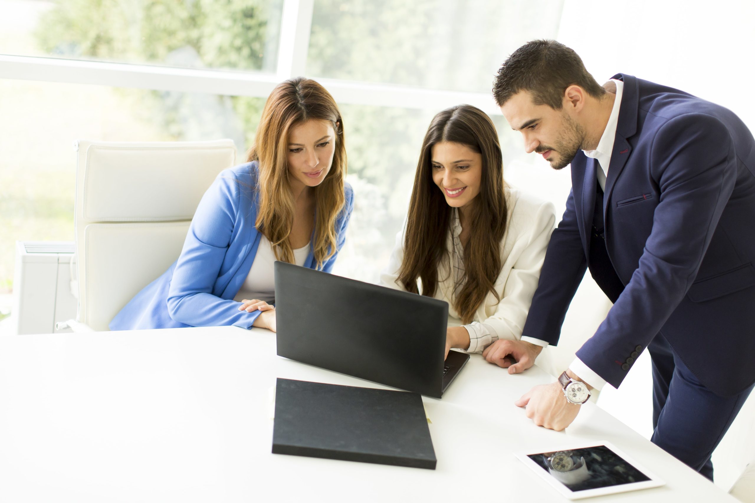 a group of people looking at a laptop