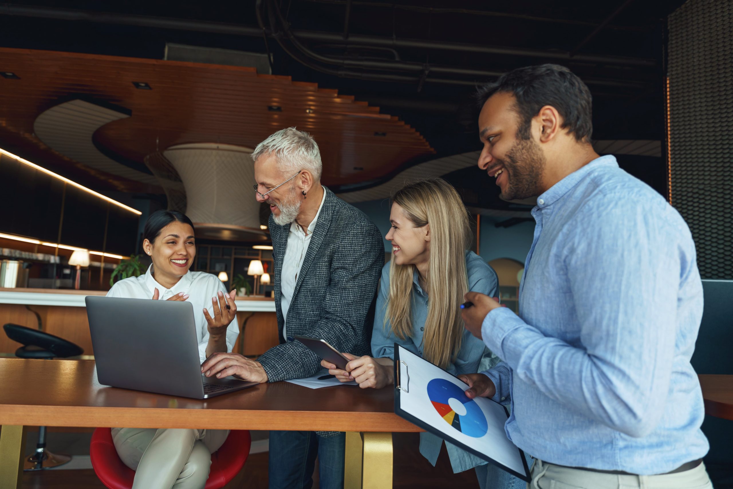 a group of people looking at a laptop