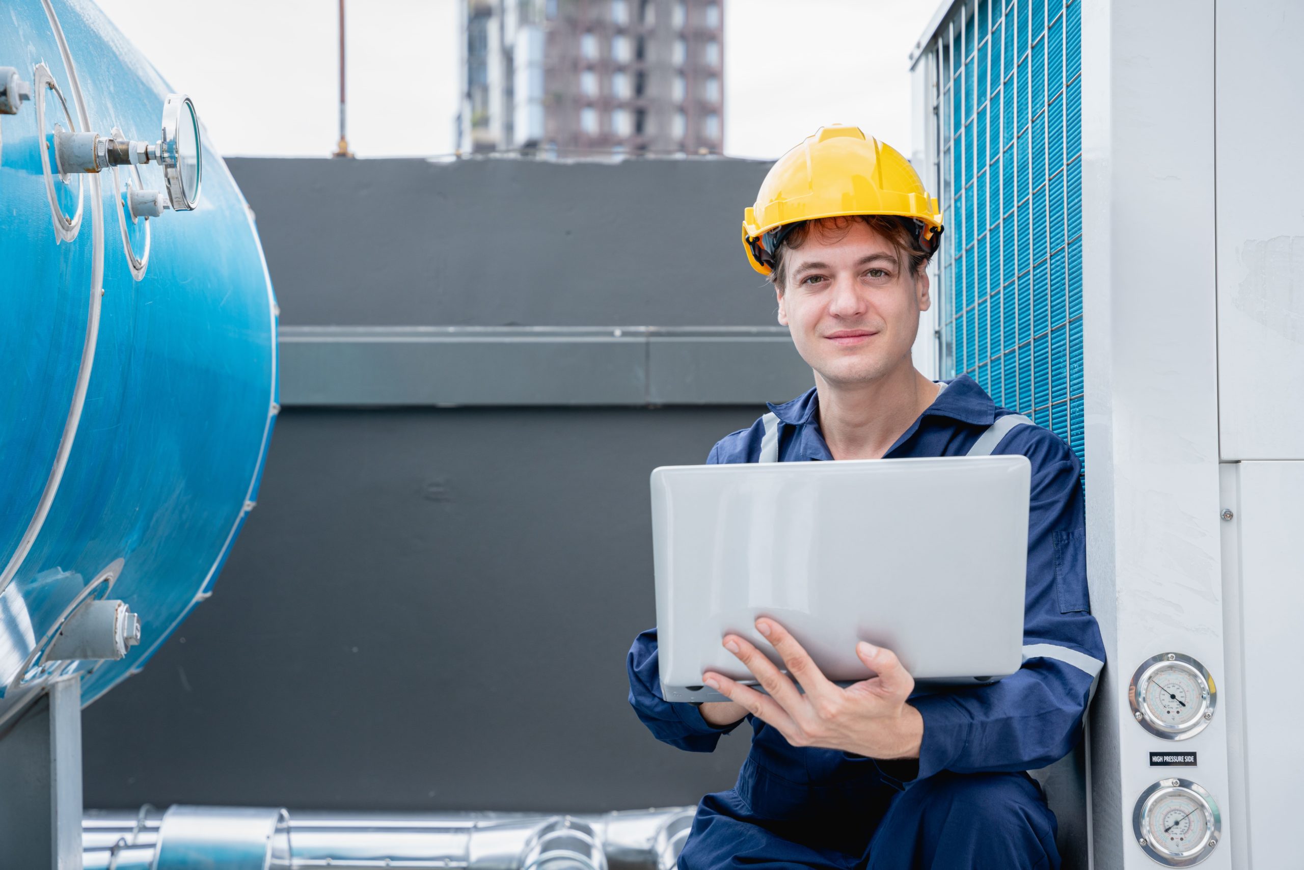 a man in a hard hat holding a laptop