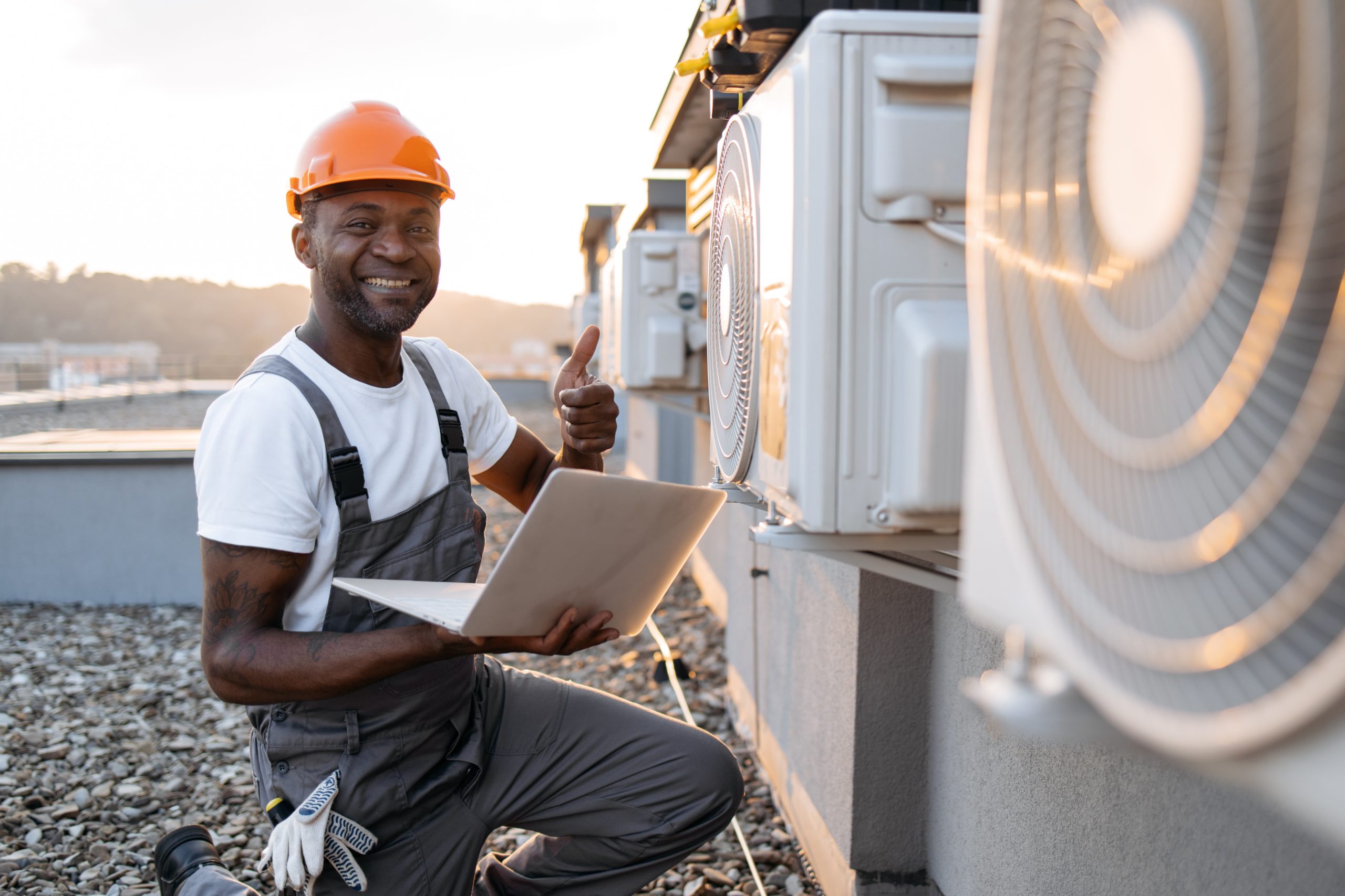 a man in a hard hat holding a laptop