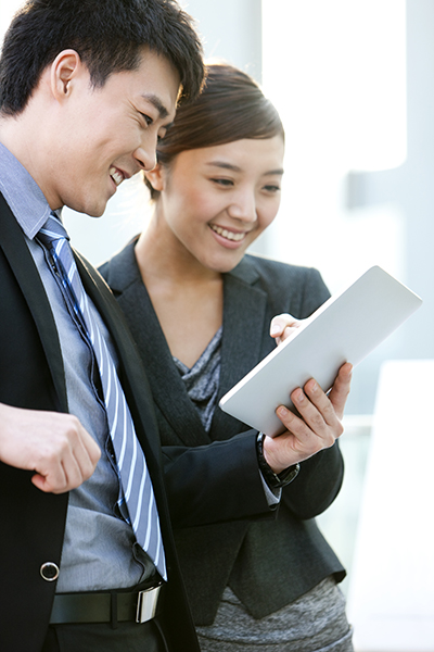 Chinese businessman and businesswoman using digital tablet