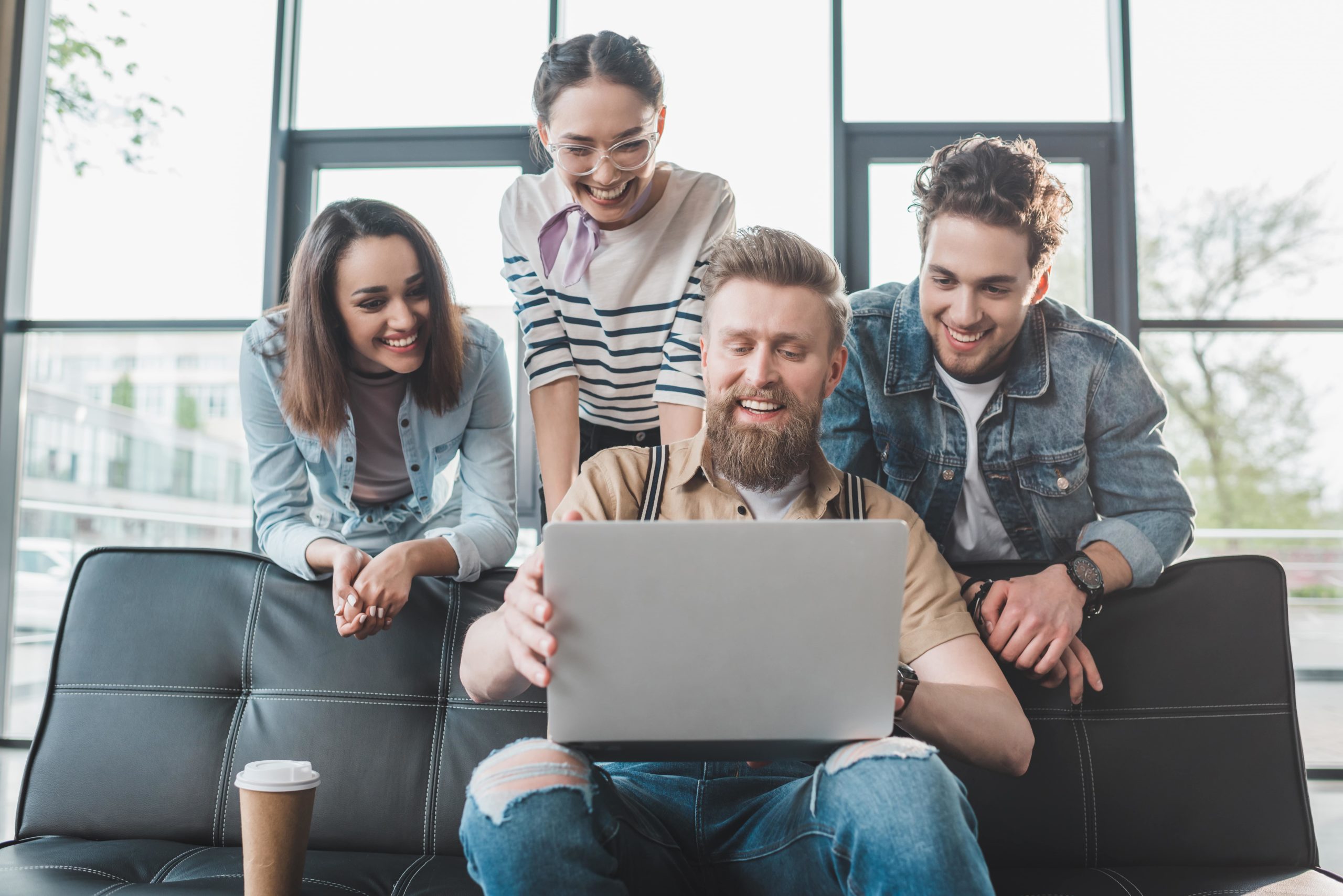 a group of people looking at a laptop