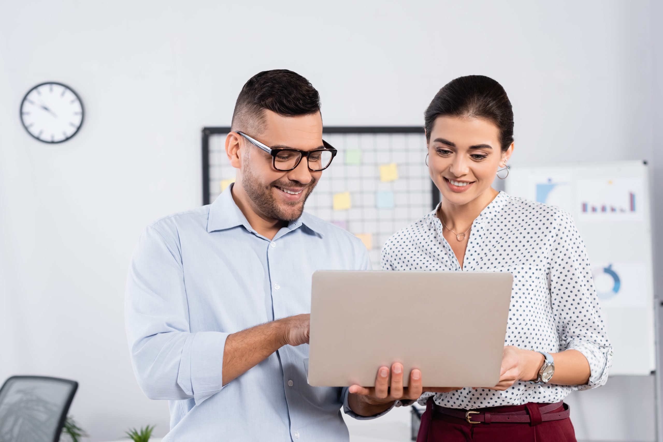 a man and woman looking at a laptop