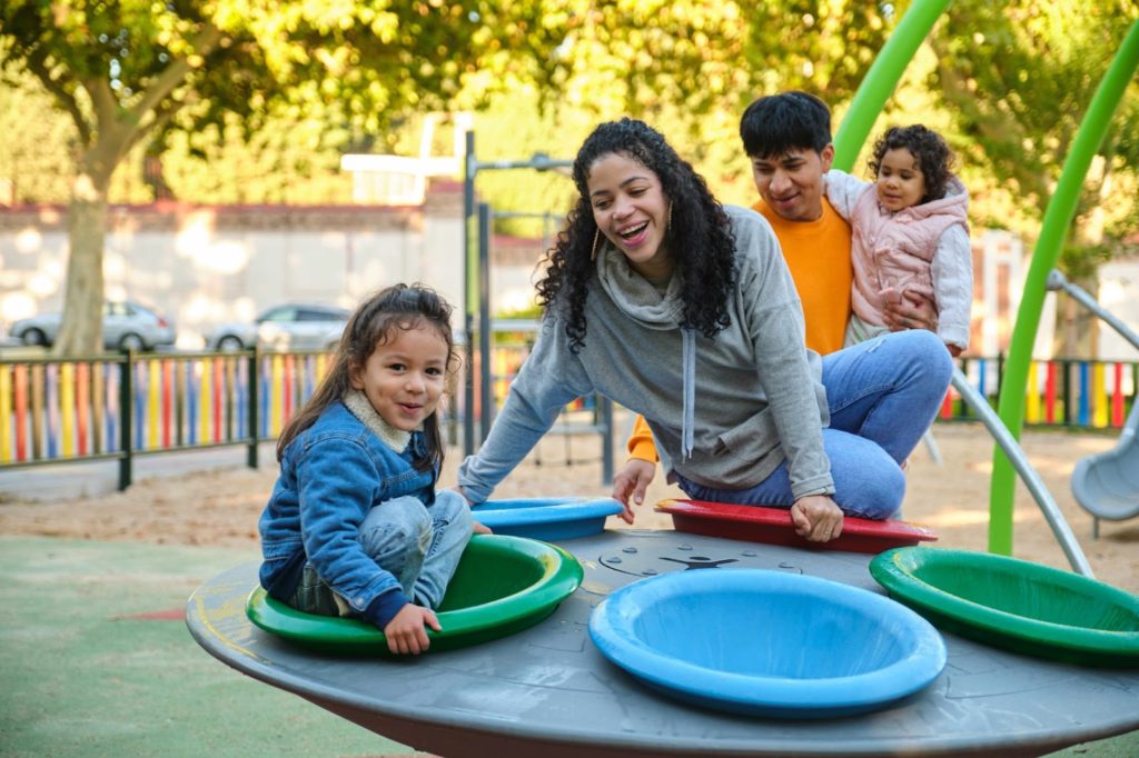 Parents and kids enjoying playtime at a playground.