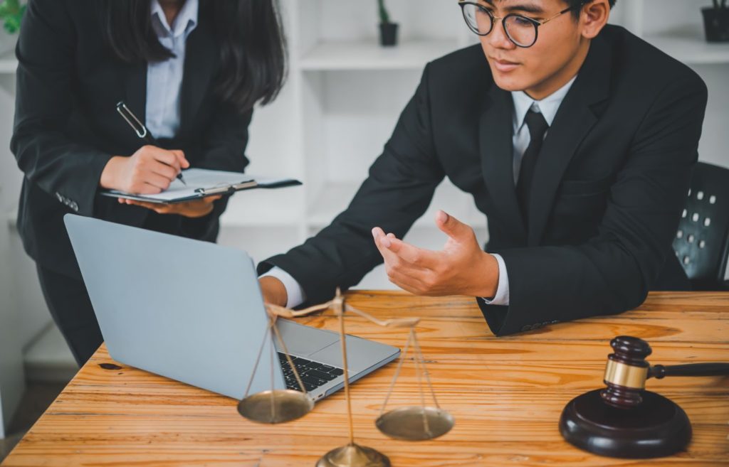 A lawyer and client discussing legal matters at a table. Professional lawfirm services provided. 