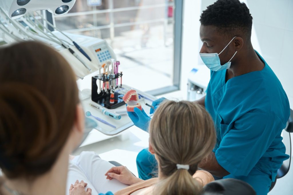 A dentist discussing treatment options with a patient in a dental clinic.