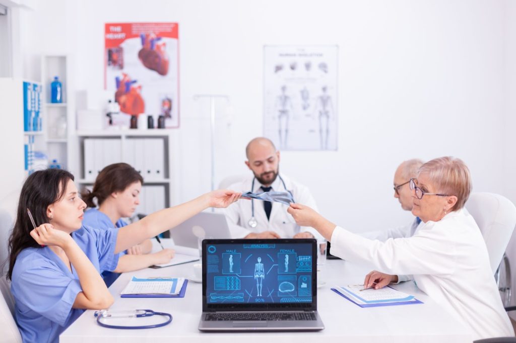 A diverse team of medical professionals discussing in a meeting room, collaborating to provide quality healthcare.