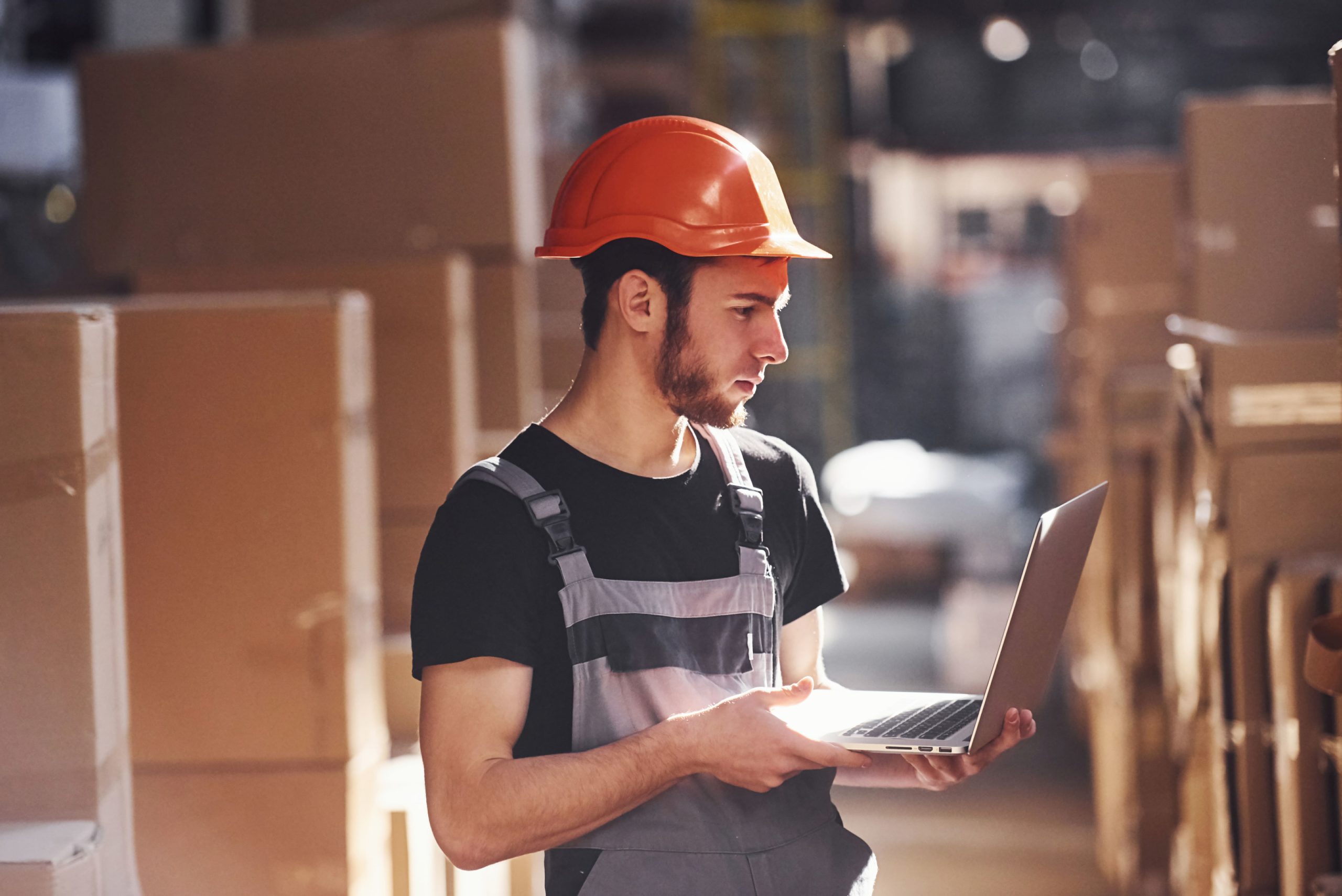 a man in a hard hat holding a laptop