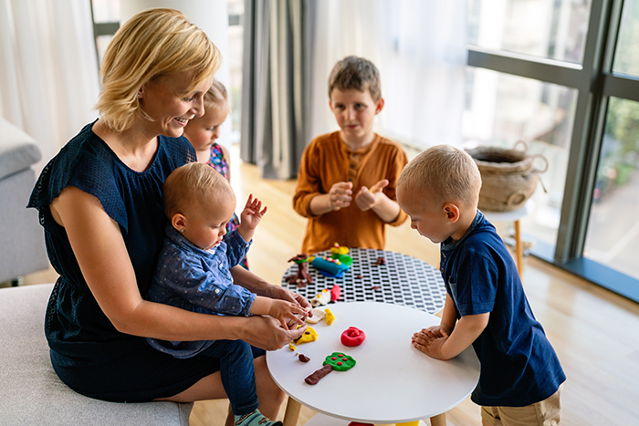 Mother teaches preschooler kids to do craft items. Family, children, education, happiness concept.