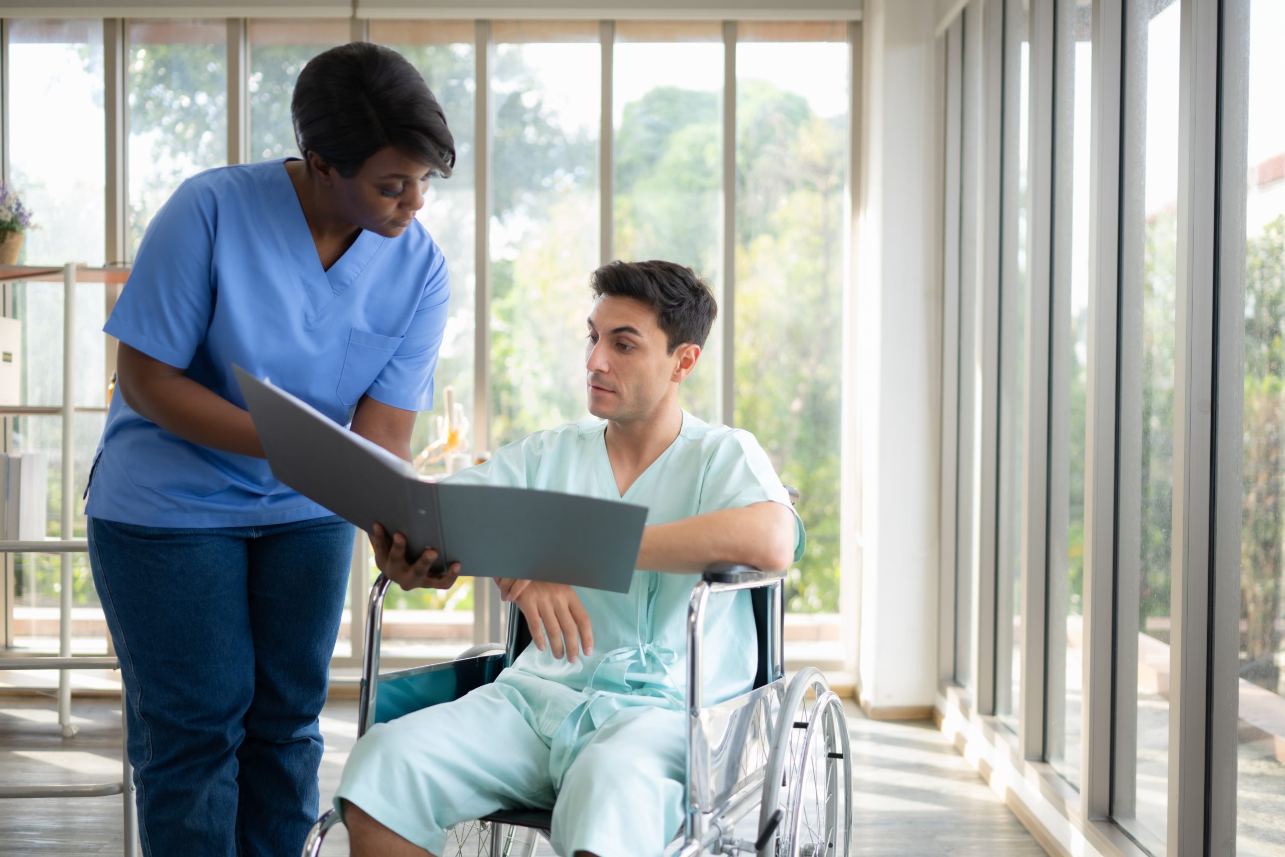 a nurse looking at a patient in a wheelchair