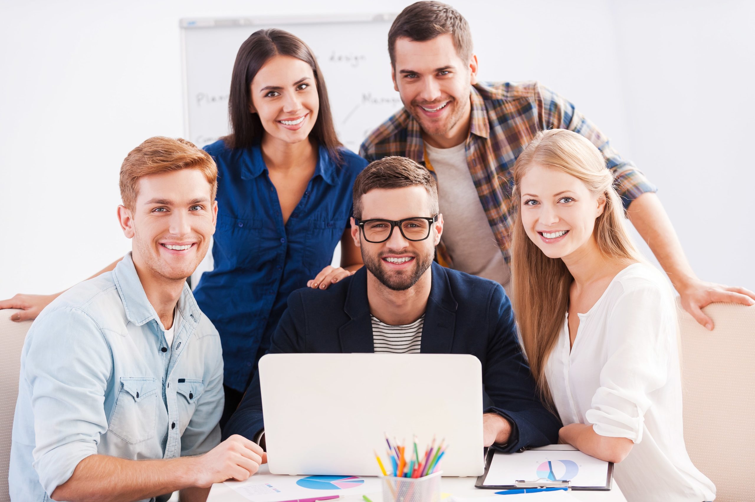 a group of people around a laptop