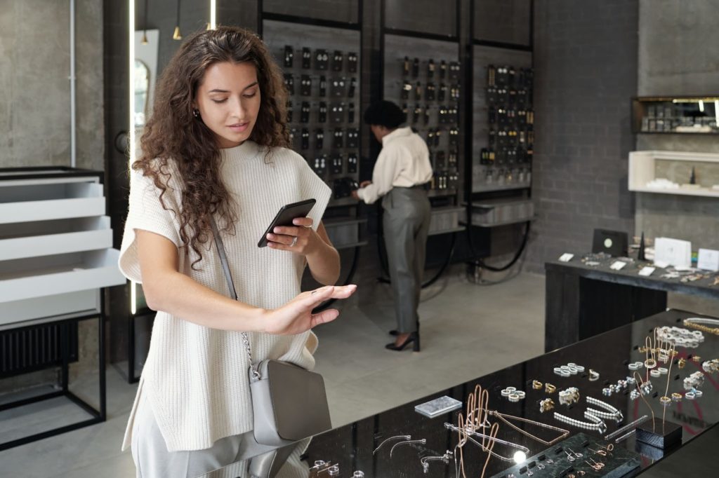 Female customer checking her phone in a jewelry shop.