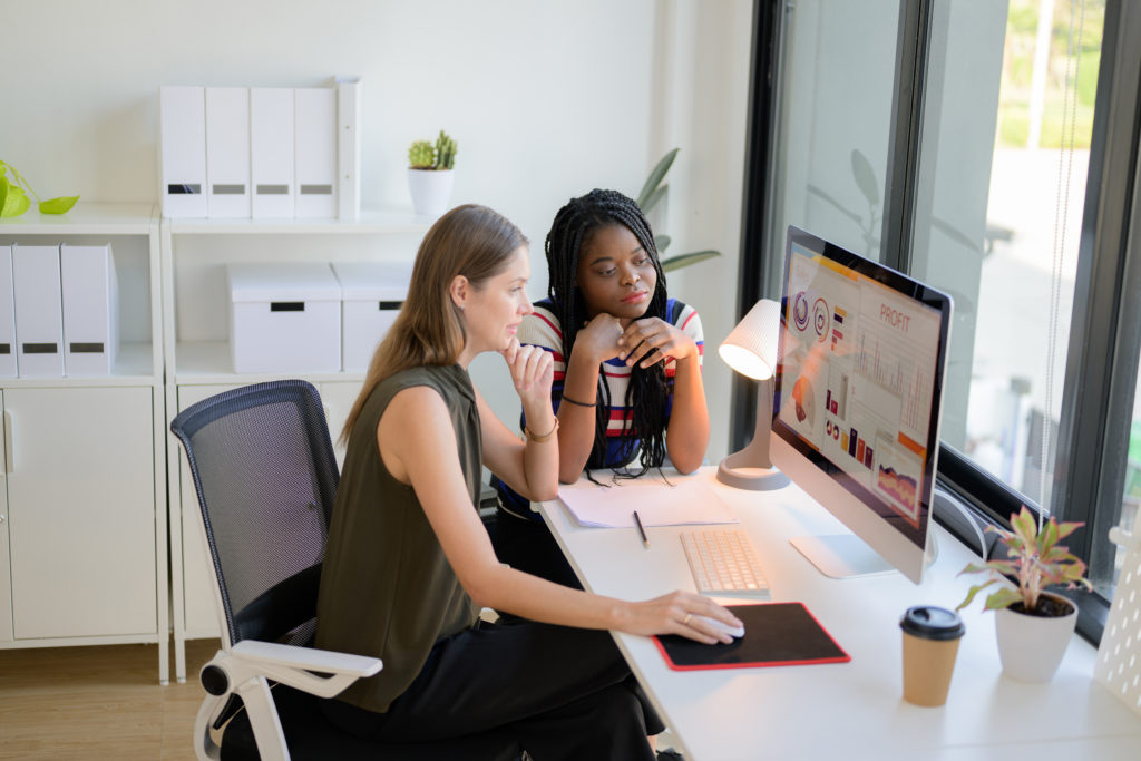 Digital marketing services team analyzing SEO, PPC, and social media performance on a desktop computer screen during a meeting.